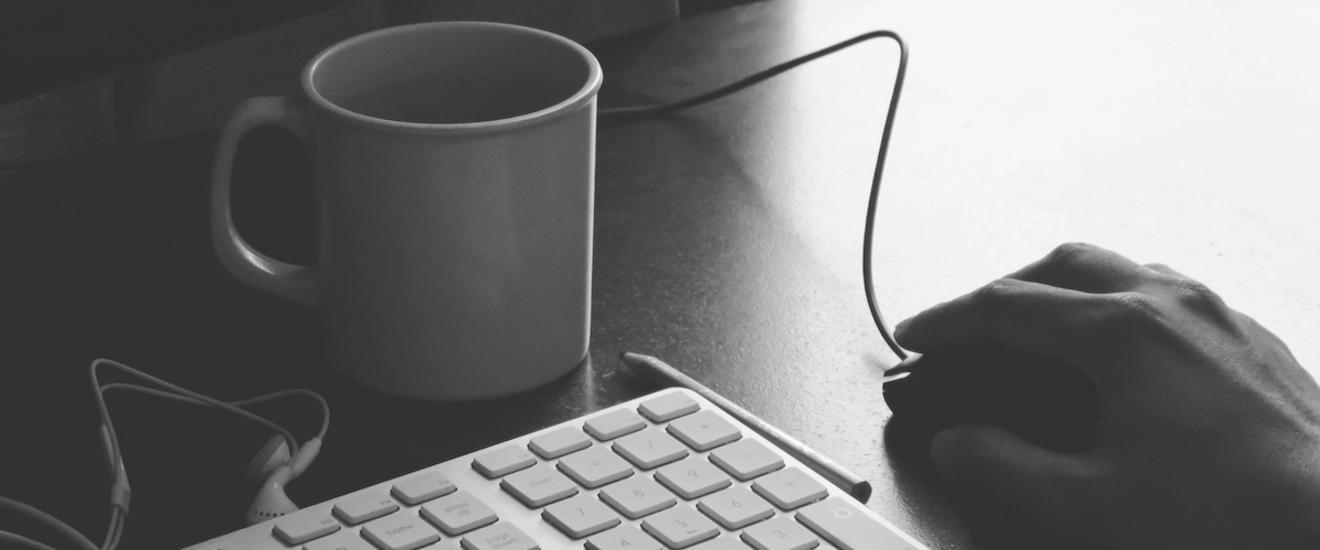 Black and white desk with coffee mug, keyboard and mouse