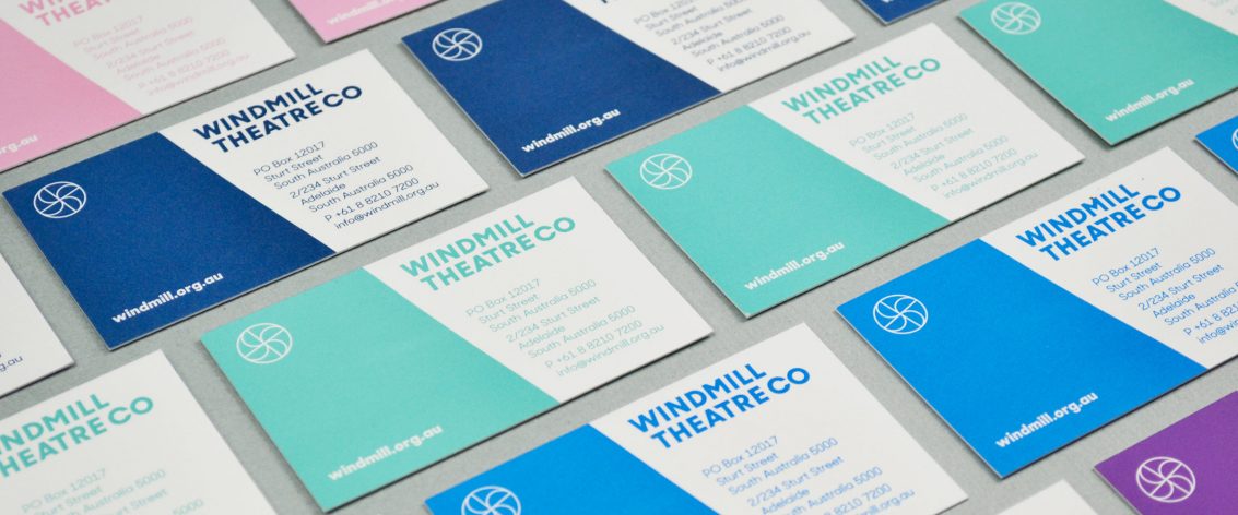 Windmill Theatre Co business cards laid out on a table designed by communikate
