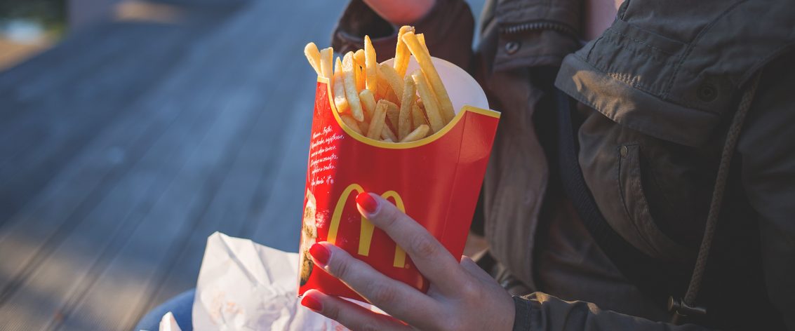 Hand holding a packet of McDonalds fries
