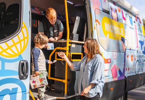 Mother, son and librarian interacting at mobile library van